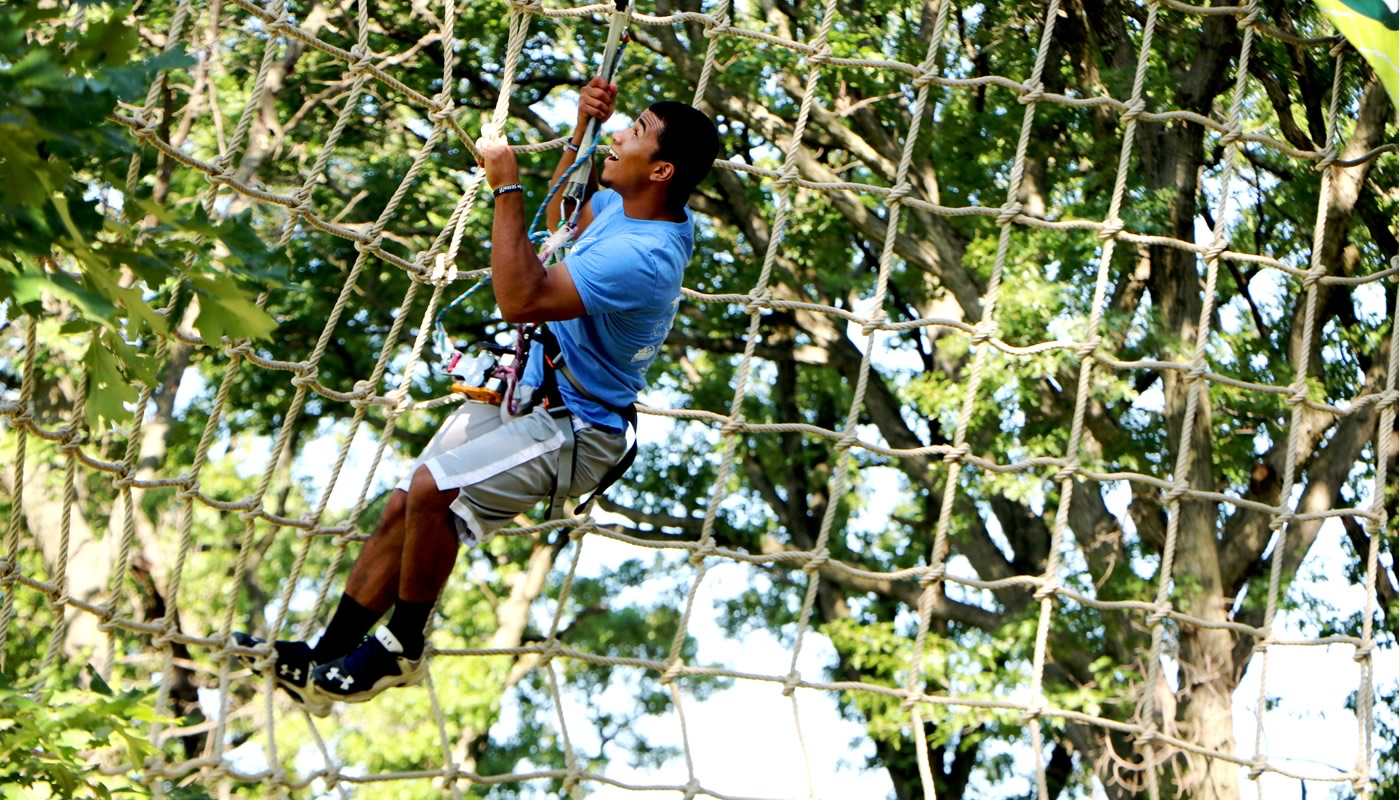 a person climbing a net on the Go Ape Tree Top Adventure Course in Bemis Woods