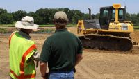 two people talking near a bulldozer